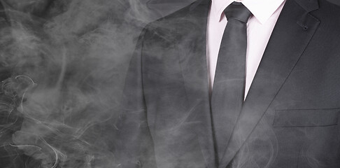 Image showing Man in a black suit, standing in smoke, close-up