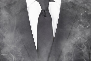 Image showing Man in a black suit, standing in smoke, close-up
