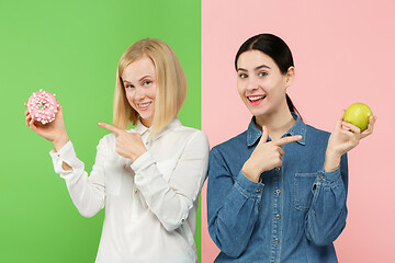 Image showing Diet. Dieting concept. Healthy Food. Beautiful Young Women choosing between fruits and unhelathy cake