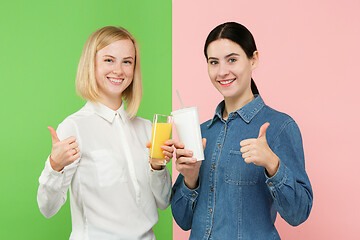 Image showing Diet. Dieting concept. Healthy Food. Beautiful Young Women choosing between fruit orange juice and unhelathy carbonated sweet drink