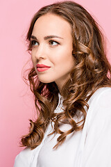 Image showing The happy business woman standing and smiling against pink background.