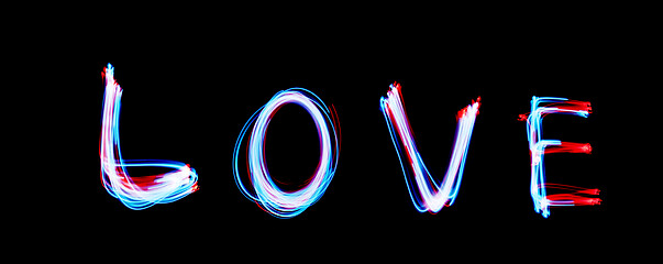 Image showing Glowing inscription LOVE on a black background