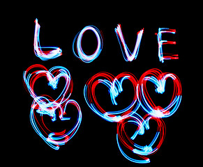 Image showing Glowing inscription LOVE on a black background