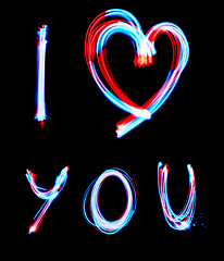 Image showing Glowing inscription LOVE on a black background