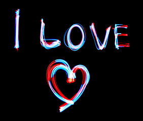 Image showing Glowing inscription LOVE on a black background