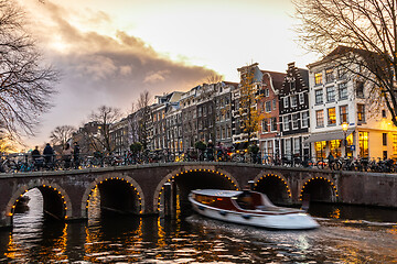 Image showing Beautiful tranquil scene of city of Amsterdam at dusk. Bicycles along the street and on the bridge over the canal.