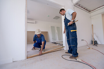 Image showing carpenters installing glass door with a wooden frame