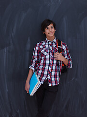 Image showing arab teenager  with school backpack and books against black chal