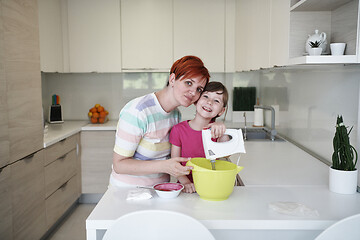 Image showing Mother and daughter playing and preparing dough in the kitchen.