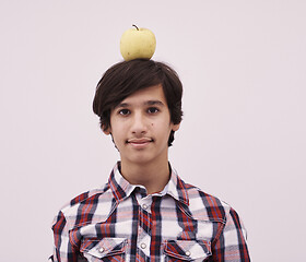 Image showing portrait of a young  teen boy with an apple on his head