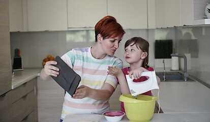 Image showing Mother and daughter playing and preparing dough in the kitchen.