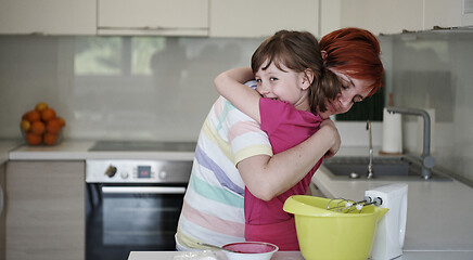 Image showing Mother and daughter playing and preparing dough in the kitchen.