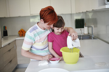 Image showing Mother and daughter playing and preparing dough in the kitchen.