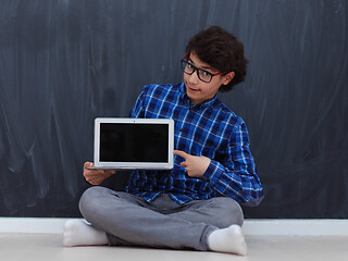 Image showing Arab teenager using laptop to work on homework  at home