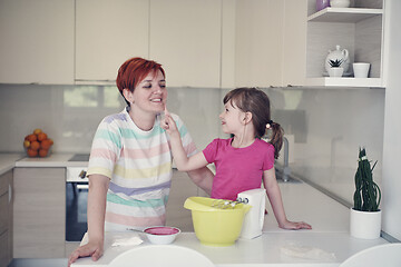 Image showing Mother and daughter playing and preparing dough in the kitchen.