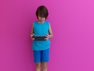 Image showing Little Arabian boy using  on digital tablet pink background