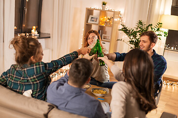 Image showing friends clinking drinks at home in evening