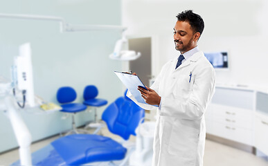 Image showing indian dentist with clipboard at dental clinic