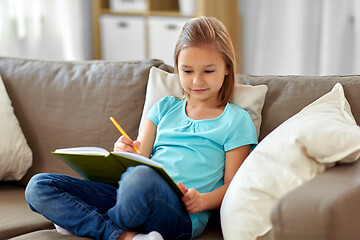 Image showing little girl with diary sitting on sofa at home