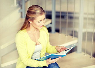 Image showing smiling high school student girl reading book