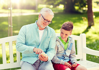 Image showing old man and boy with smartphones at summer park