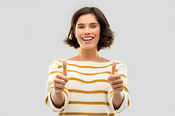 Image showing smiling woman in pullover showing thumbs up