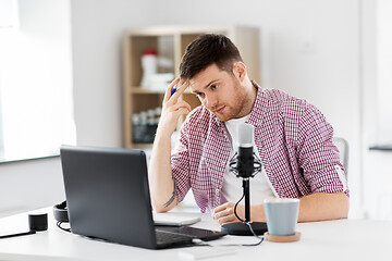 Image showing audio blogger with laptop, microphone and notebook