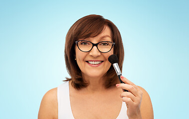 Image showing smiling senior woman with make up blush brush