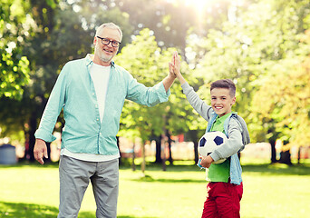 Image showing old man and boy with soccer ball making high five