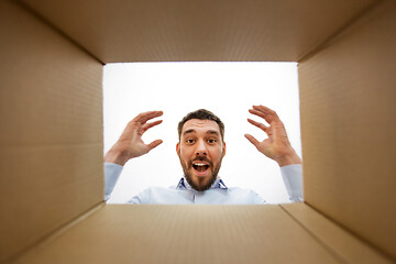 Image showing happy suprised man looking into open parcel box