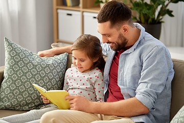 Image showing happy father and daughter reading book at home