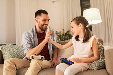 Image showing father and daughter playing video game at home