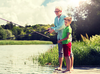 Image showing grandfather and grandson fishing on river berth