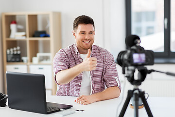 Image showing male blogger with camera videoblogging at home