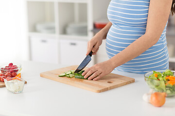 Image showing pregnant woman cooking vegetable salad at home