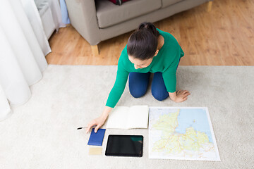 Image showing woman with notebook and travel map at home