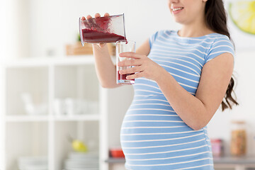 Image showing pregnant woman pouring fruit smoothie at home