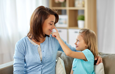 Image showing mother and daughter sitting on sofa at home