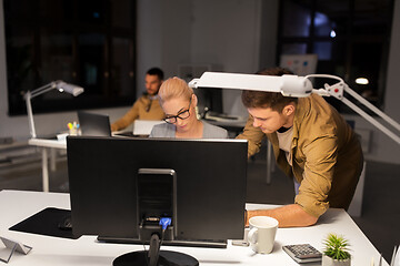 Image showing business team with computer working late at office