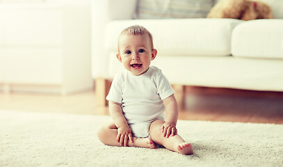 Image showing happy baby boy or girl sitting on floor at home