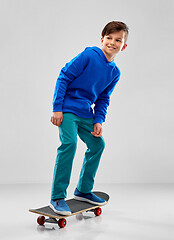 Image showing smiling boy in blue hoodie with skateboard