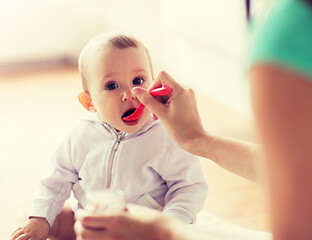 Image showing mother with spoon feeding little baby at home