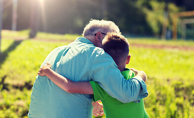 Image showing grandfather and grandson hugging outdoors