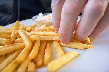 Image showing Grabbing some French fries