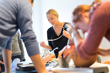 Image showing Medical doctor specialist expert displaying method of patient intubation on hands on medical education training and workshop. Participants learning new medical procedures and techniques.