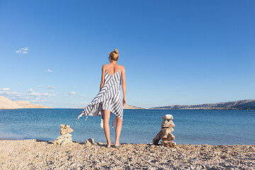 Image showing Happy carefree woman enjoying late afternoon walk on white pabbled beach on Pag island, Croatia