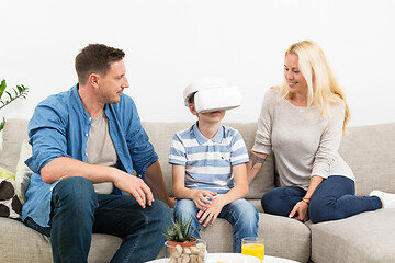 Image showing Happy family at home on living room sofa having fun playing games using virtual reality headset