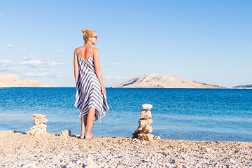 Image showing Happy carefree woman enjoying late afternoon walk on white pabbled beach on Pag island, Croatia