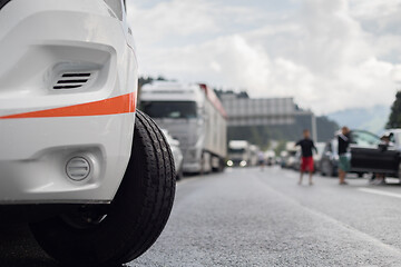 Image showing Typical scene on European highways during summer holiadays rush hour. A traffic jam with rows of cars tue to highway car accident. Empty emergency lane. Shallow depth of field