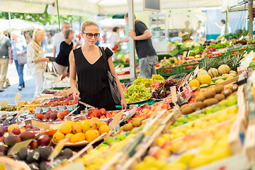 Image showing Woman buying fruits and vegetables at local food market. Market stall with variety of organic vegetable